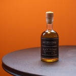 A stylised product shot of Sublime's Black Truffle Oil on an orange background