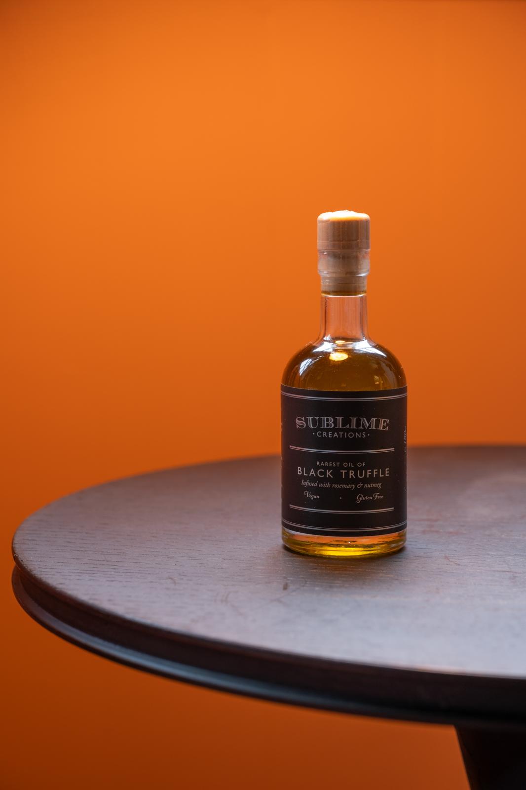 A stylised product shot of Sublime's Black Truffle Oil on an orange background