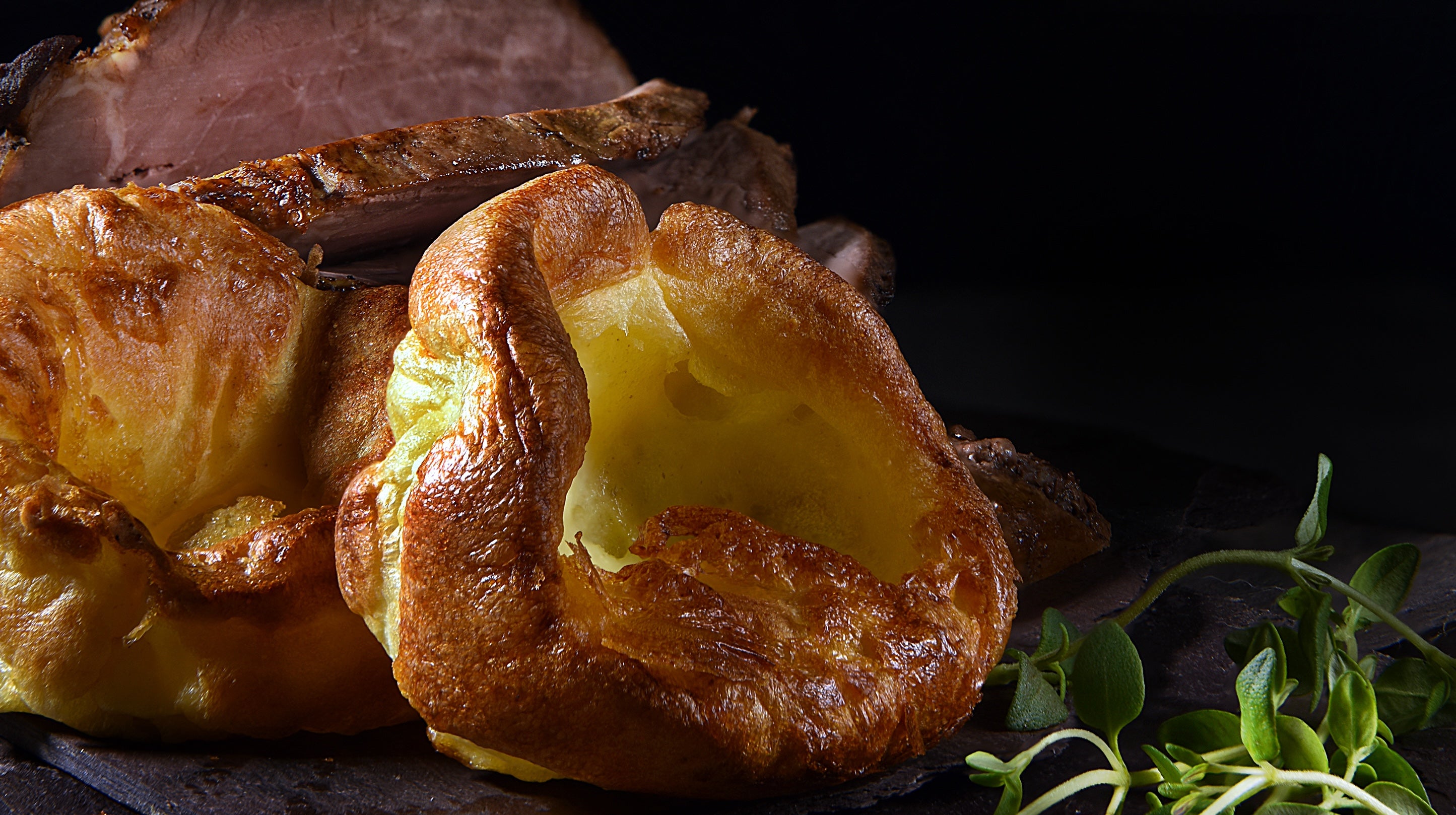 Golden Yorkshire puddings accompanying some traditional roast beef